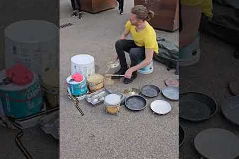 Talented busker plays the drums with old kitchen utensils